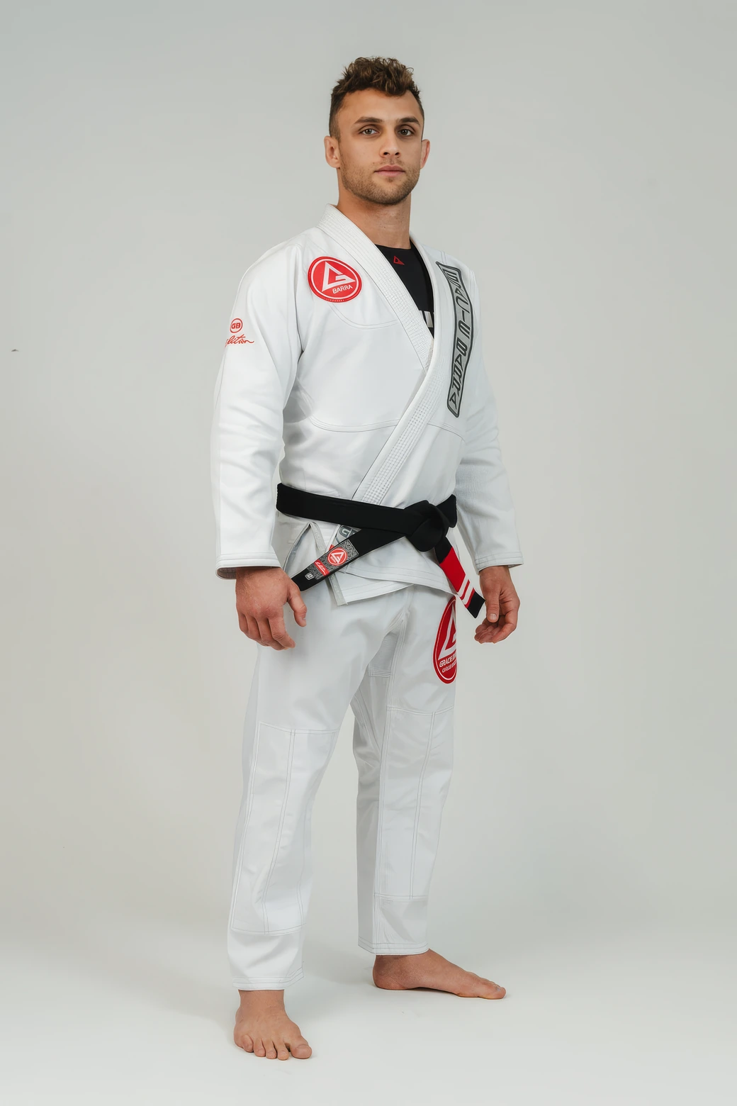 A Gracie Barra student standing in a white GB1 gi with a black belt.