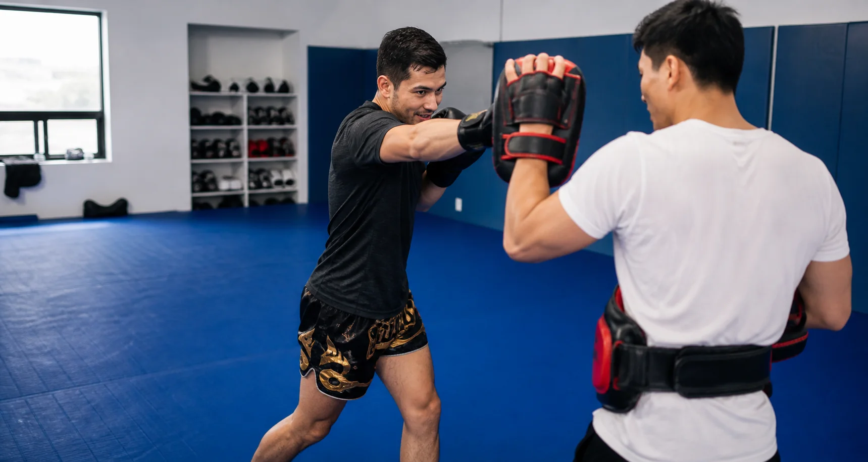 Adults training Muay Thai with focus mitts