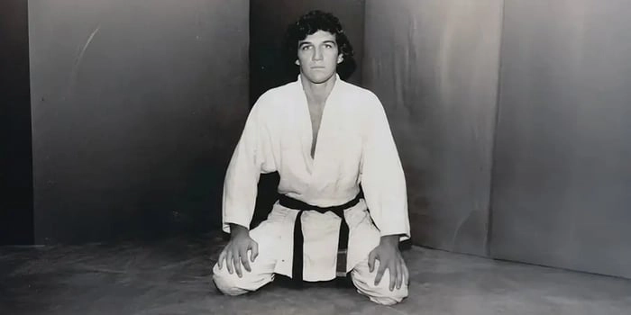 Rolls Gracie kneeling in a gi